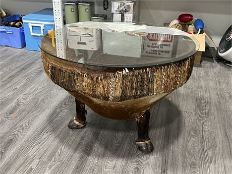 AFRICAN DRUM TABLE W/GLASS TOP & HOOF LEGS (32” wide, 21” tall)