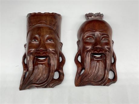 2 VINTAGE WOOD ASIAN HAND CARVED FACES (1 W/GLASS EYES, 9” TALL)