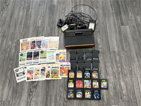 ATARI 2600 CONSOLE W/ CORDS, CONTROLLERS, MULTIPLE GAMES & MANUALS