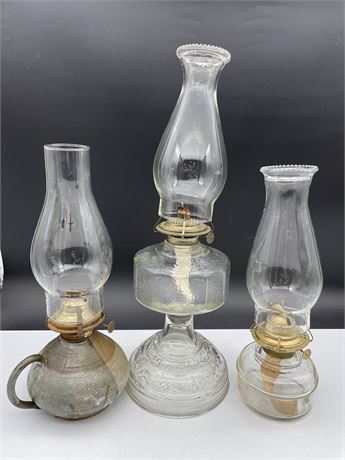 3 KEROSENE LAMPS - 2 GLASS & 1 POTTERY W/CHIMNEYS