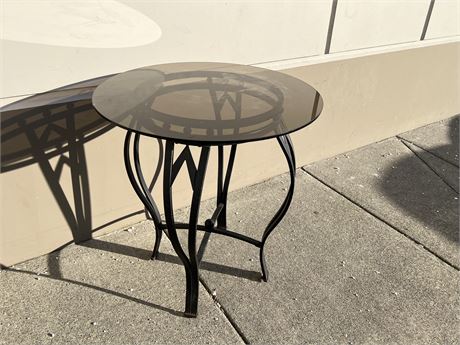 METAL / WROUGHT IRON OUTDOOR TABLE W/ SMOKEY GLASS TOP - GLASS TOP HAS SCRATCHES