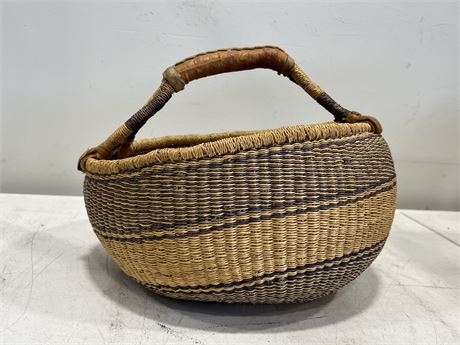 VINTAGE HAND WOVEN BASKET W/LEATHER HANDLE (16” wide)